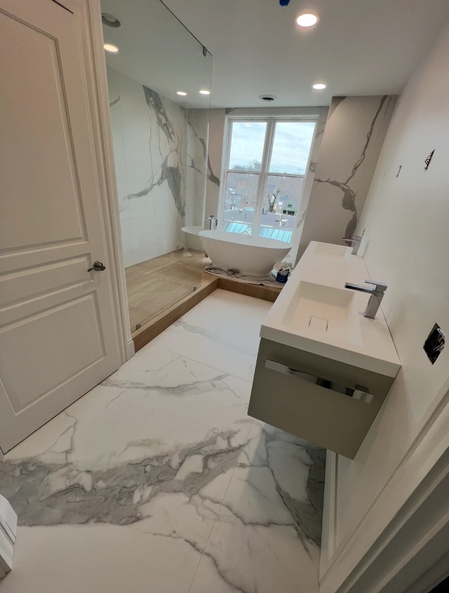 Primary bathroom remodel with porcelain slab walls, freestanding tub and floating double vanity