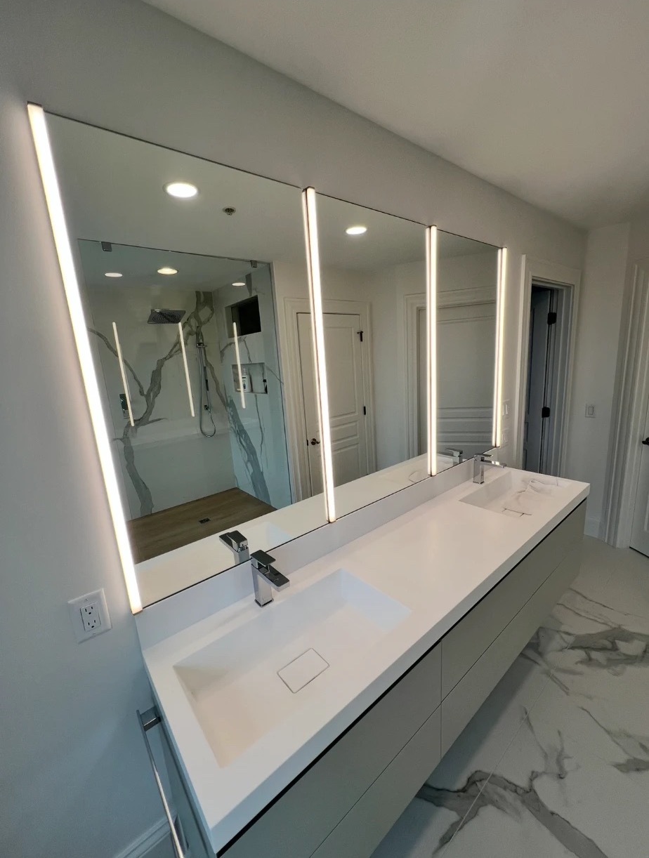 Floating double vanity with integrated sinks and lit mirrors